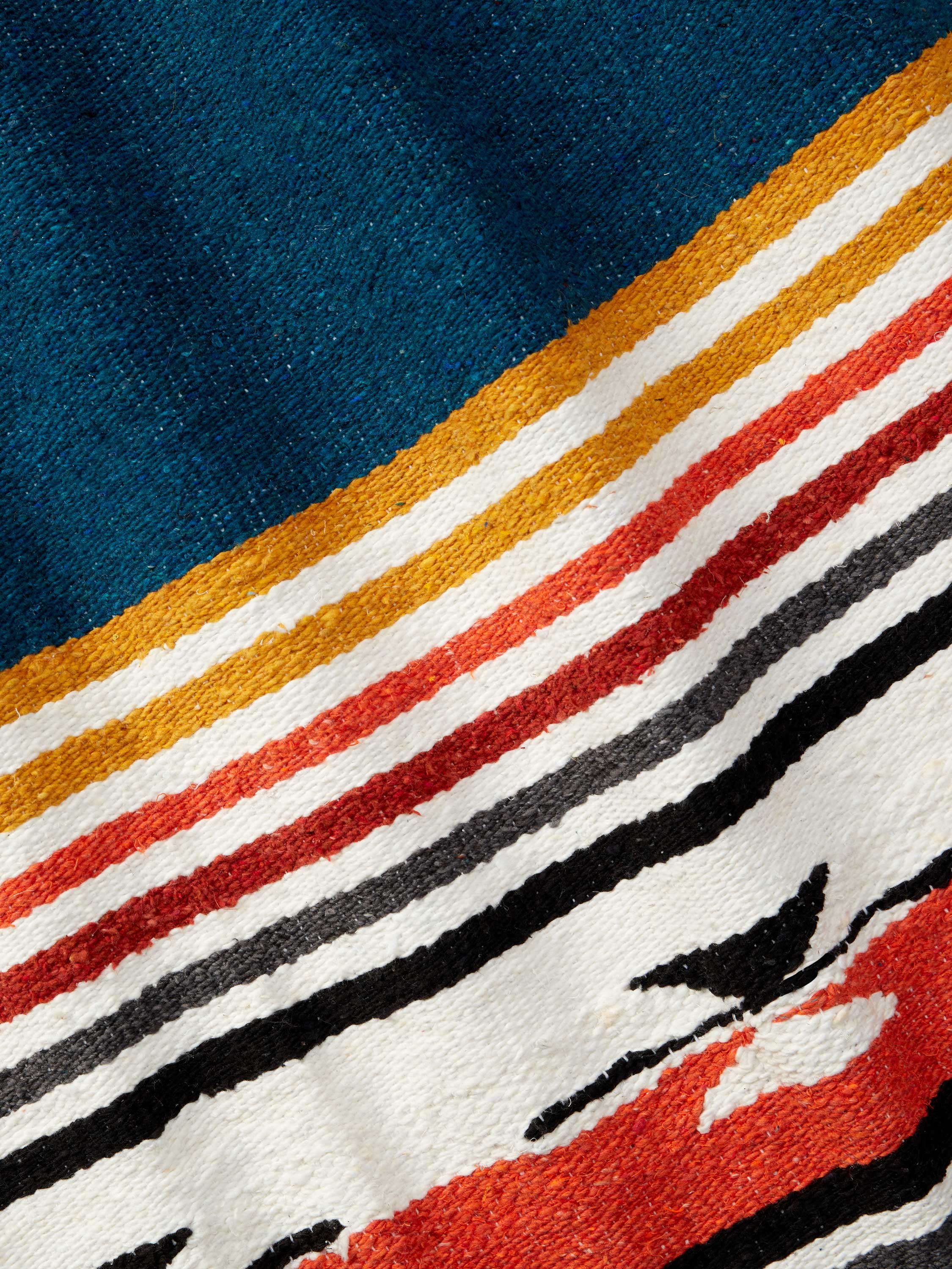 Close-up of a textured fabric with colorful stripes and abstract patterns.