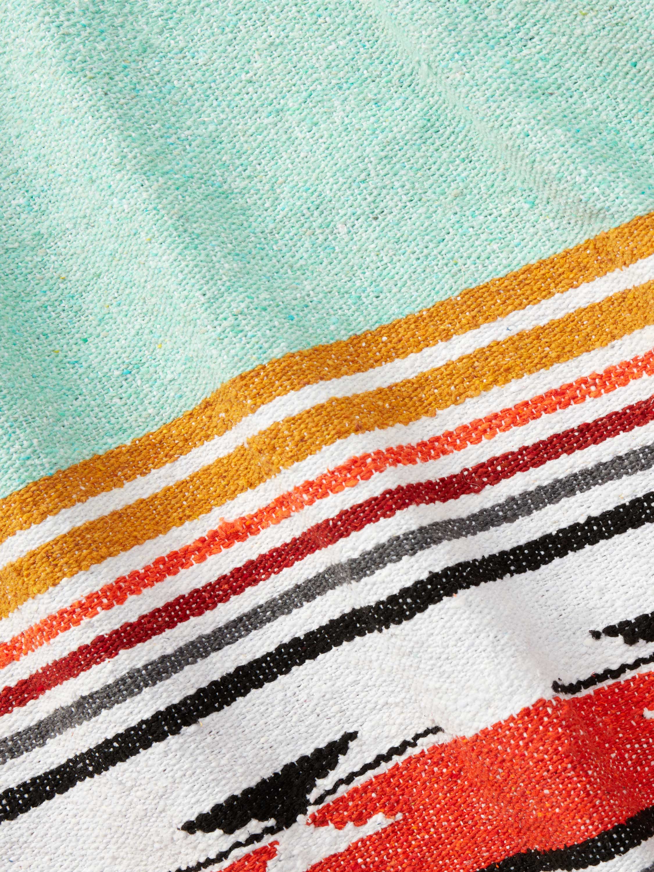 Close-up of a fabric with colorful stripes on a light blue background