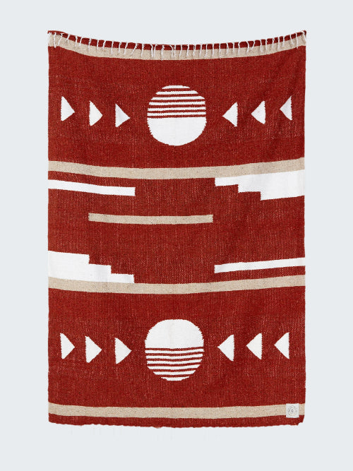 Red blanket with geometric patterns on a white background