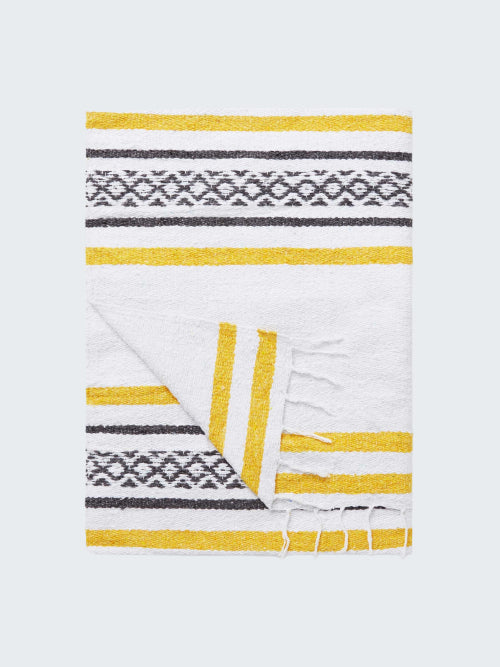 Folded blanket with yellow and gray pattern on a white background