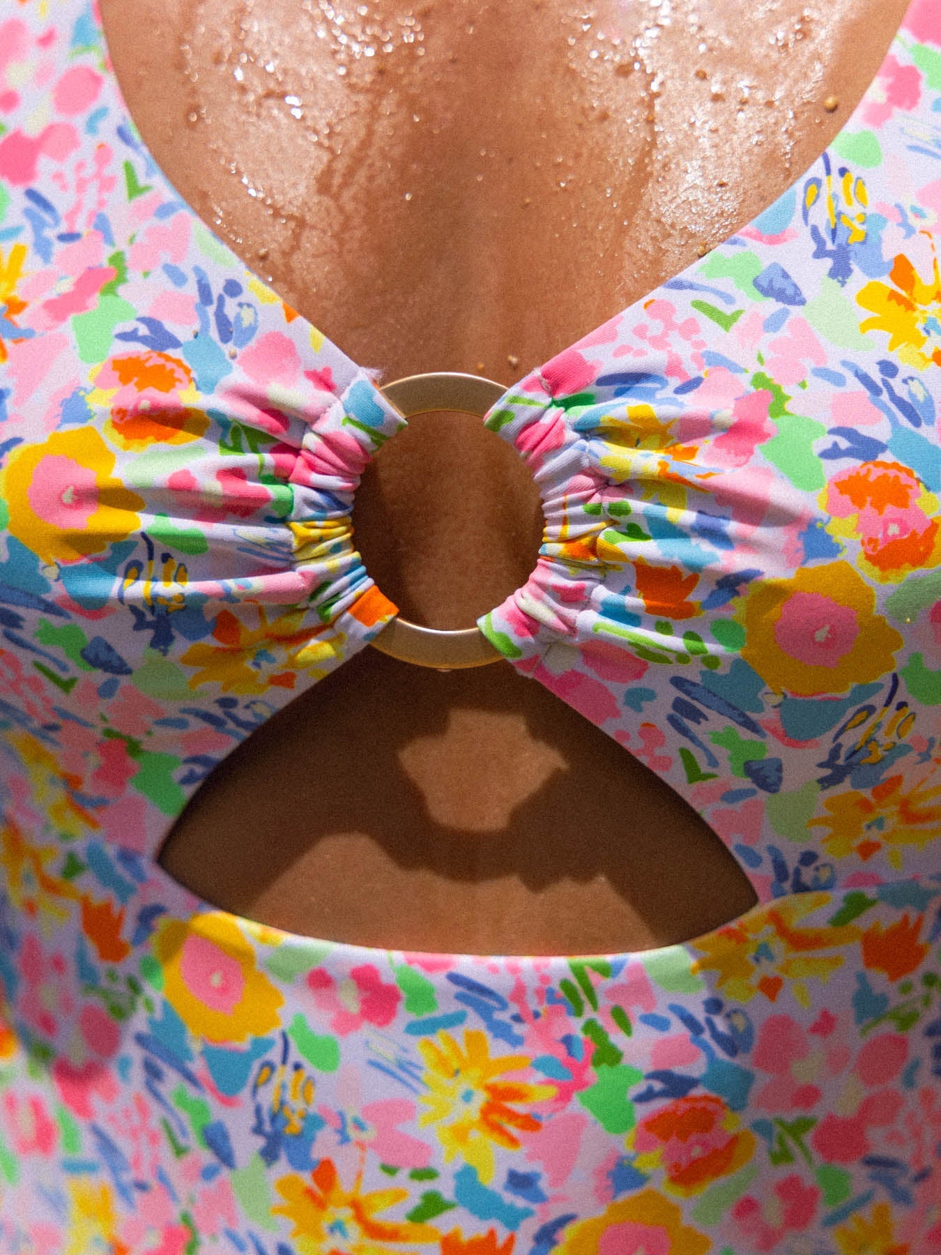 Colorful floral swimsuit with a bow detail on a person.