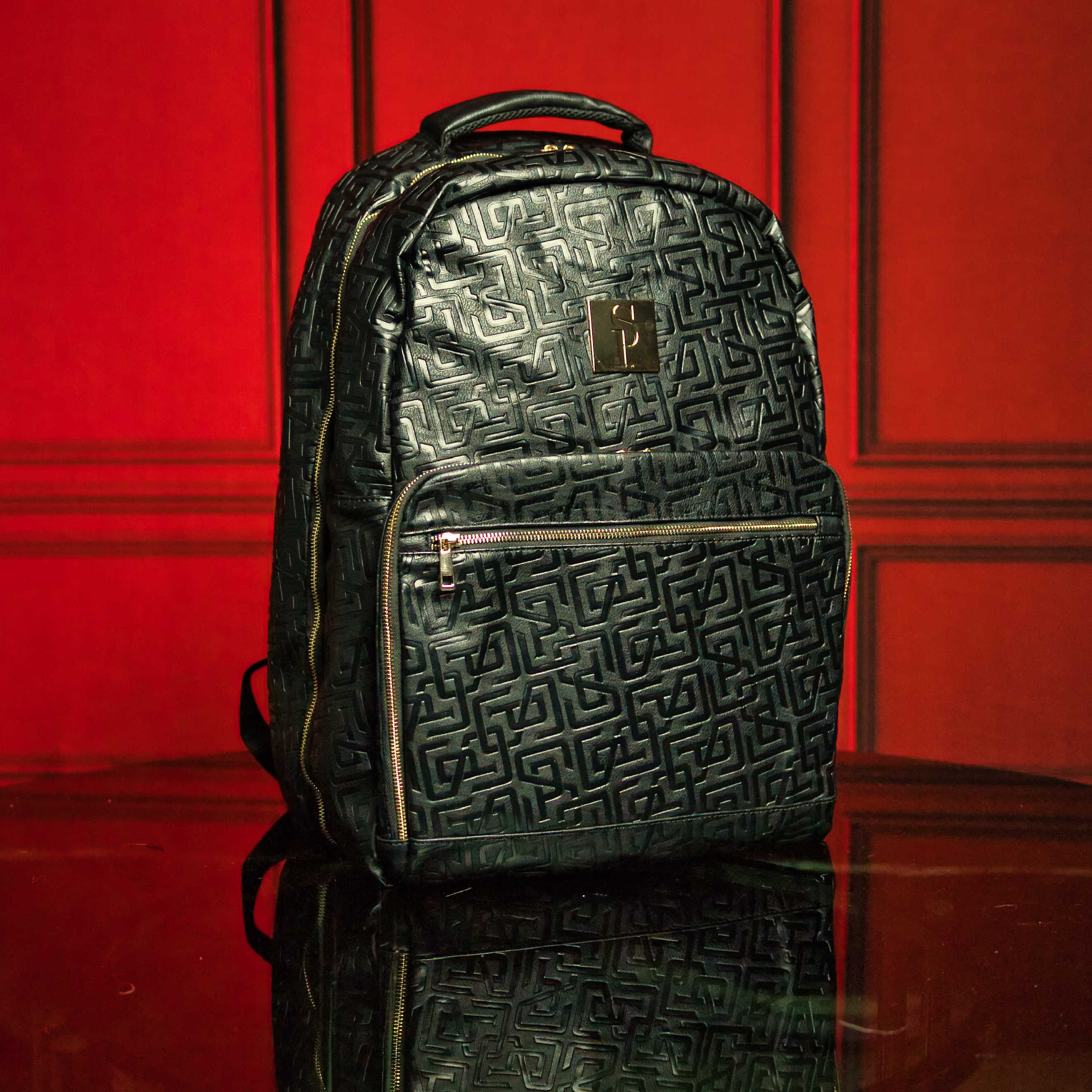 Black textured backpack with a logo on a red background