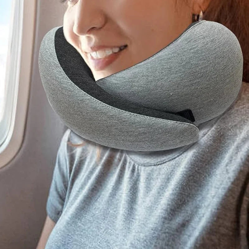 Person using a gray travel neck pillow on a plane