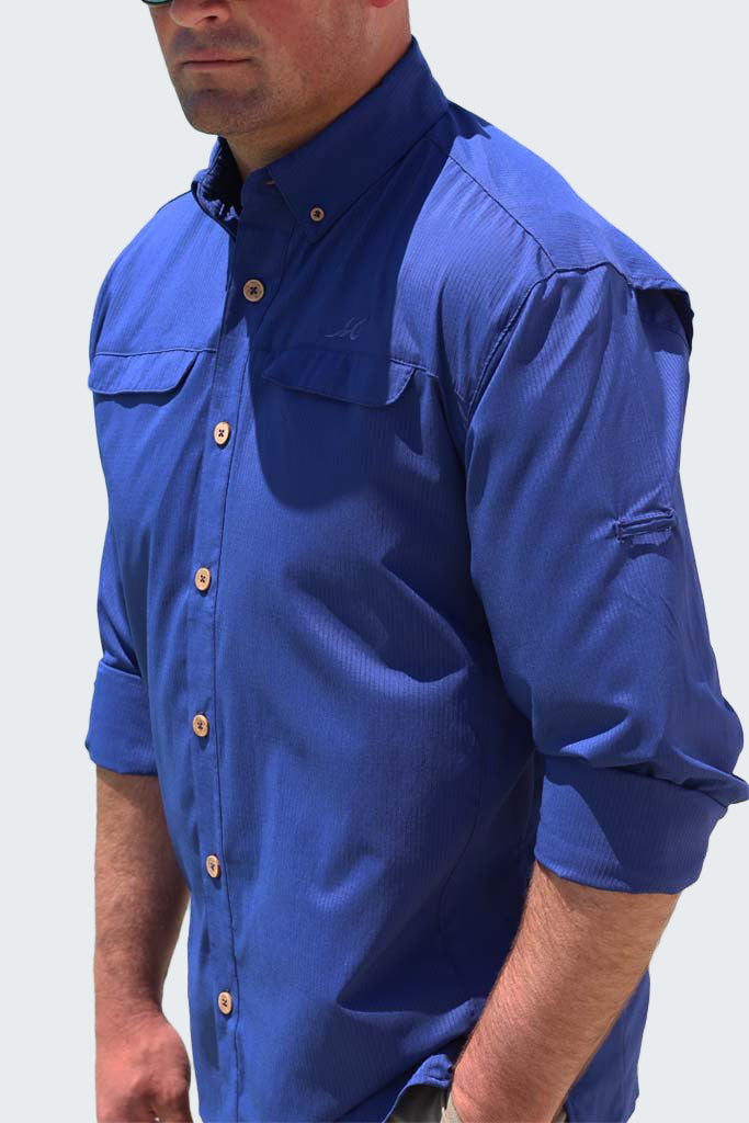 Man wearing a blue shirt with rolled-up sleeves on a white background