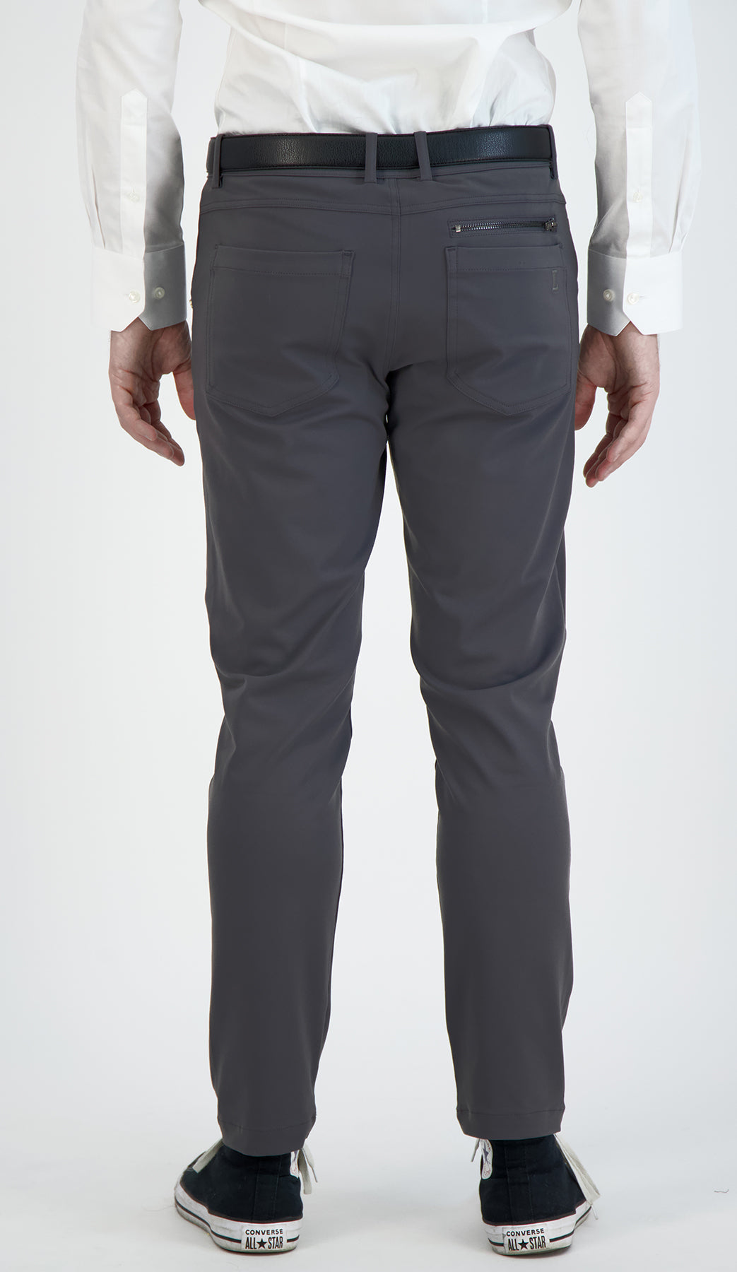 Person wearing gray pants with a white shirt on a white background