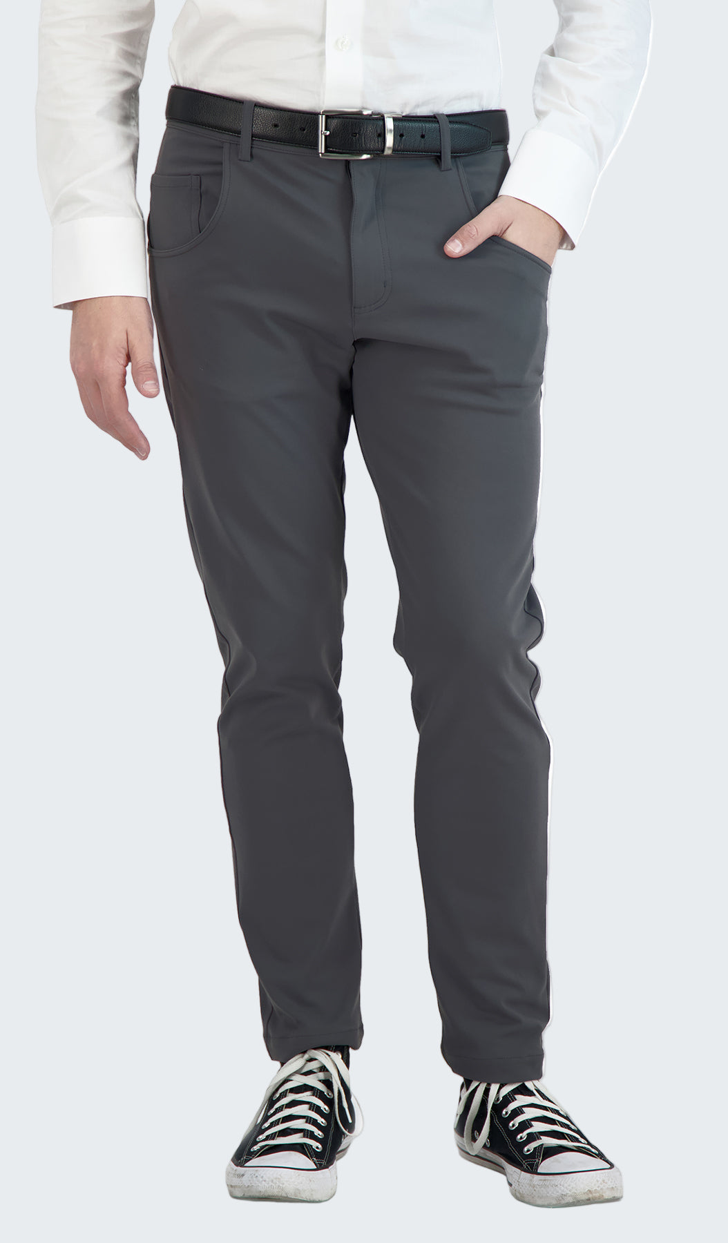 Person wearing gray pants and black sneakers on a white background