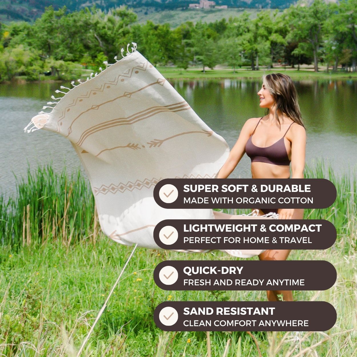 Woman holding a white towel with text about its features, standing by a lake.