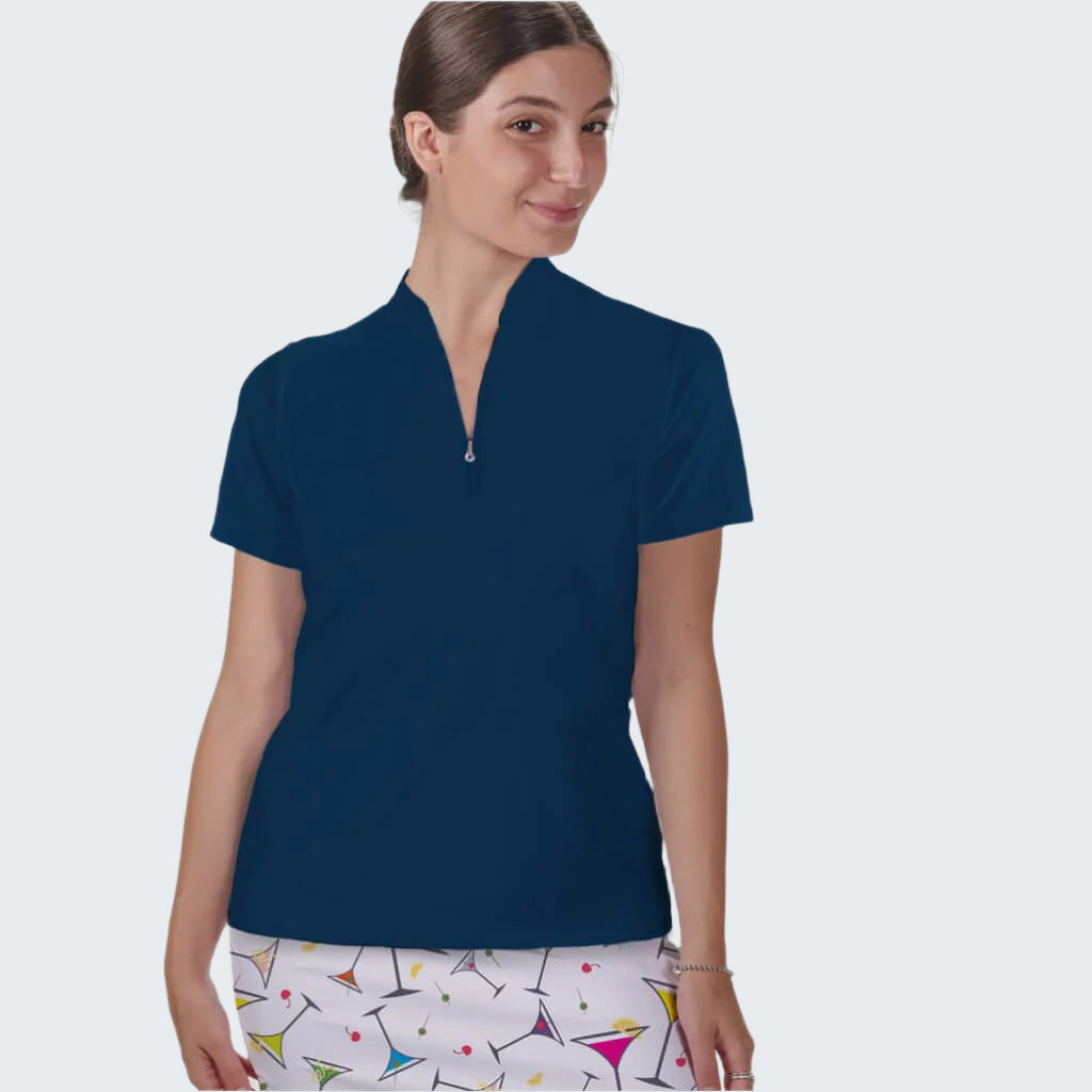 Woman wearing a navy blue polo shirt and colorful skirt on a white background