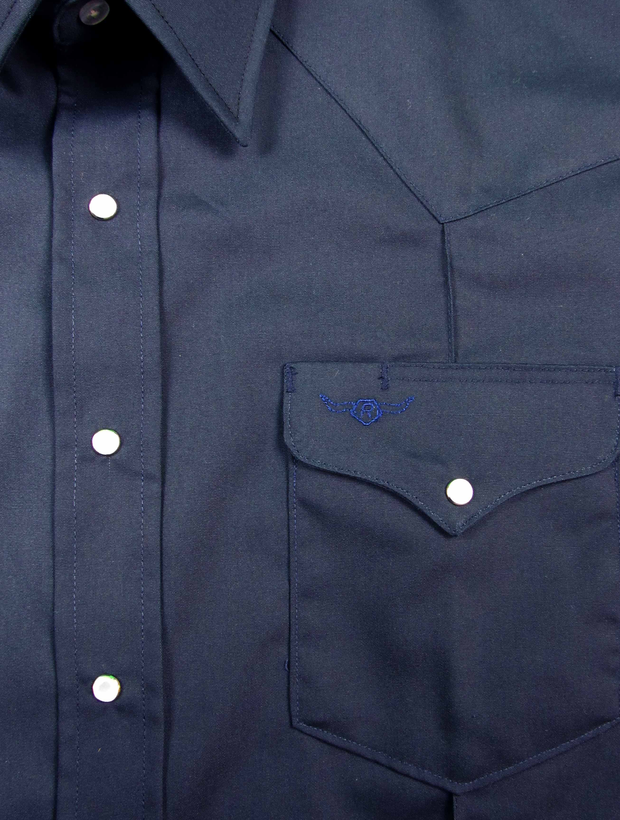 Close-up of a navy blue shirt with button details and a pocket emblem.