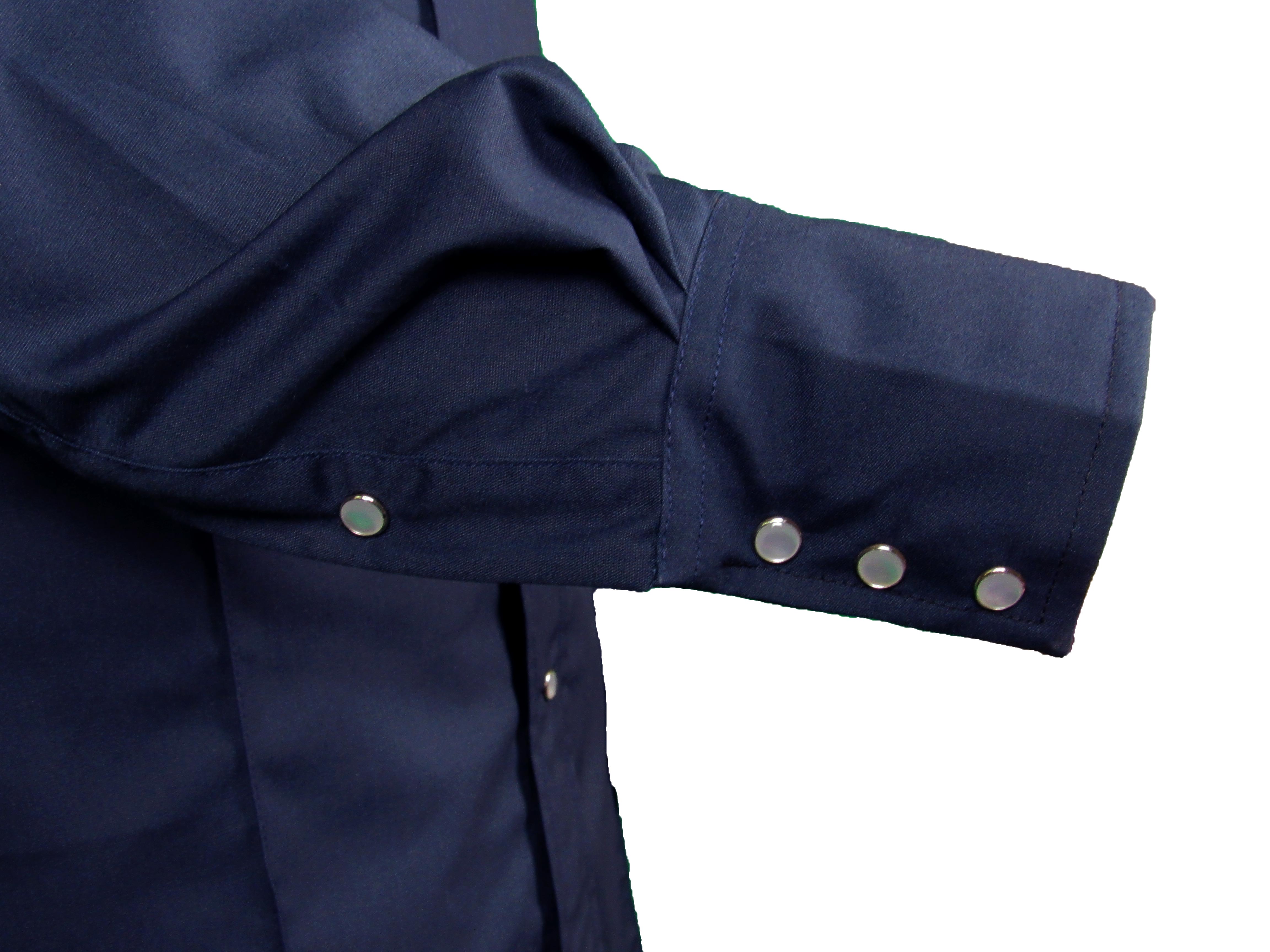 Close-up of a navy blue shirt with rolled-up sleeves on a white background