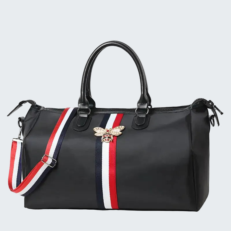 Black handbag with a bee emblem and colorful strap on a white background