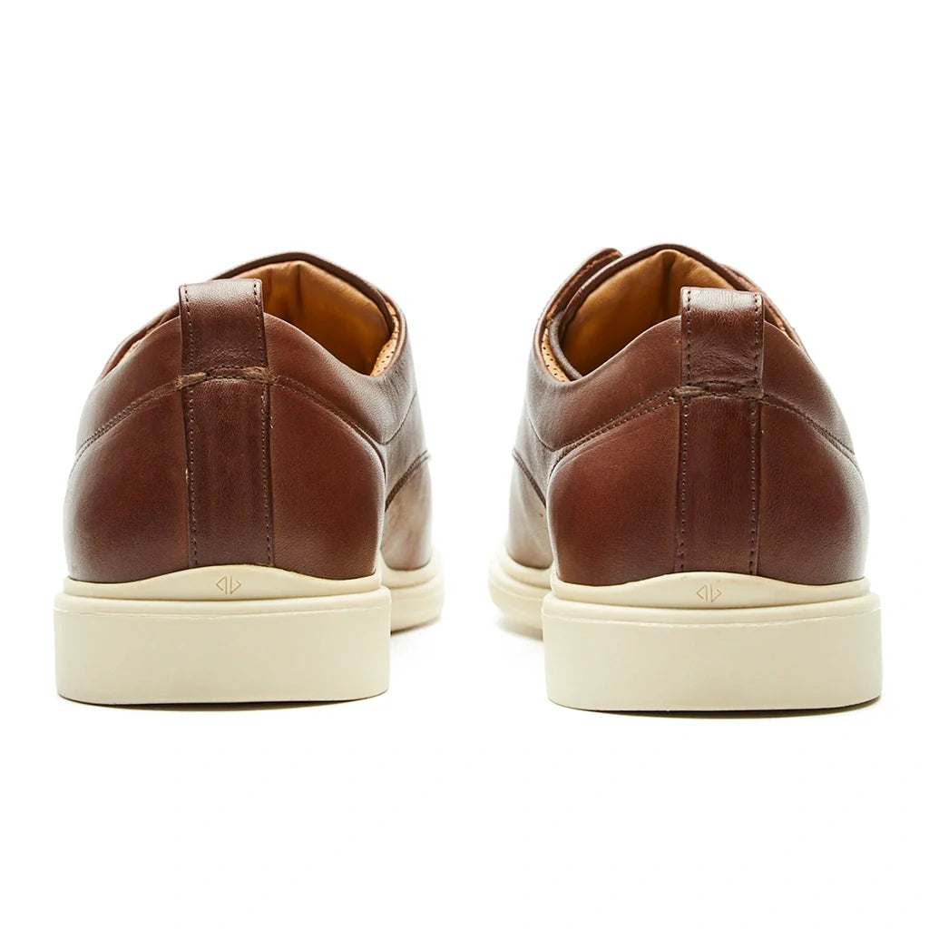 Brown leather shoes with white soles on a white background