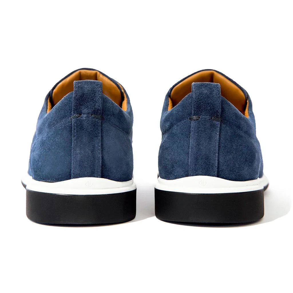 Blue suede shoes with white soles on a white background