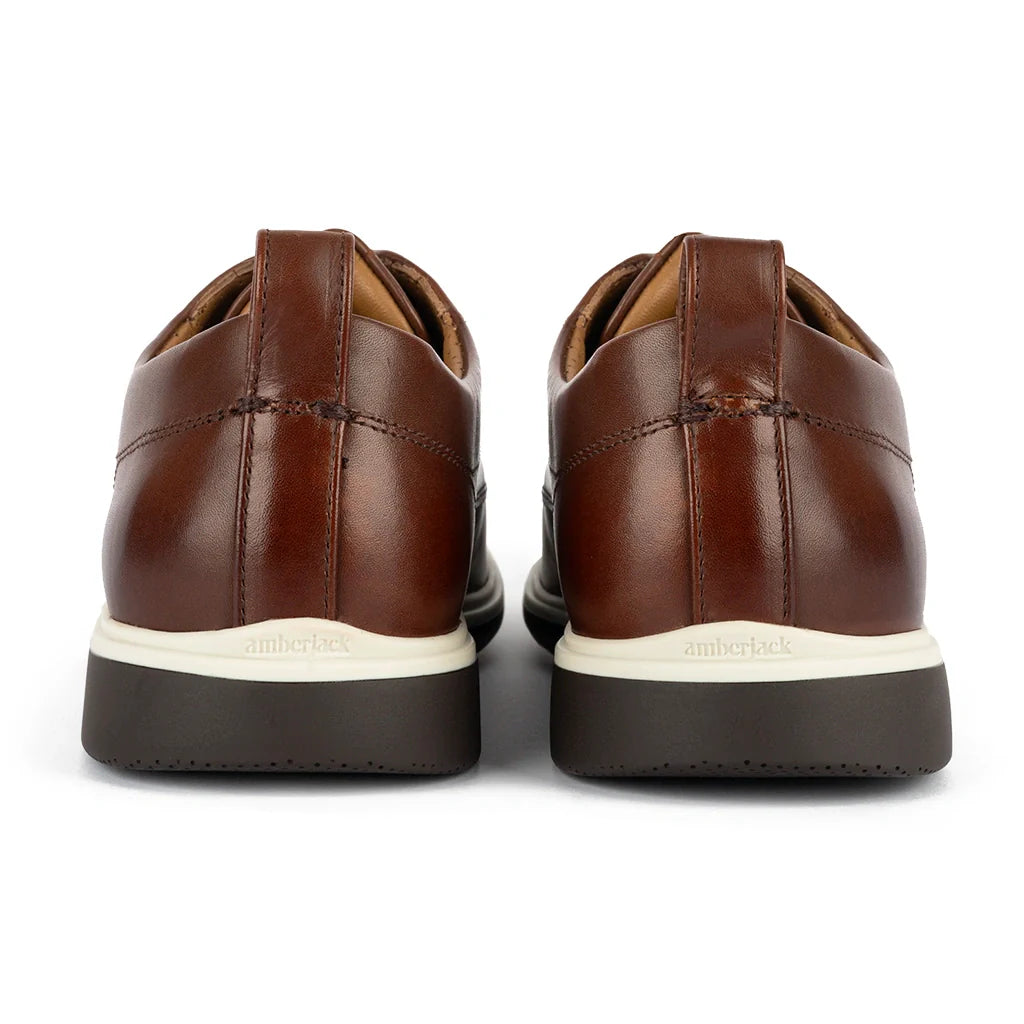 Brown leather shoes with white soles on a white background