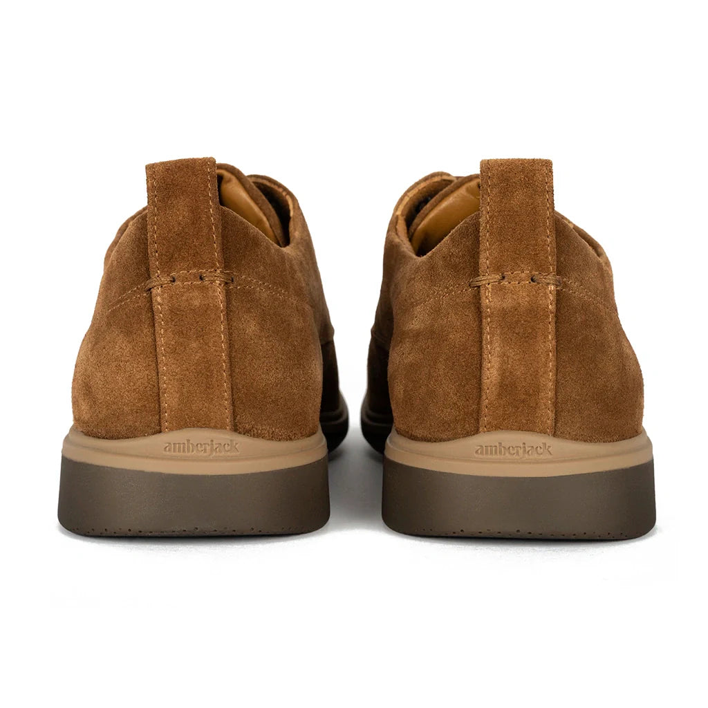 Pair of brown suede shoes with a white background