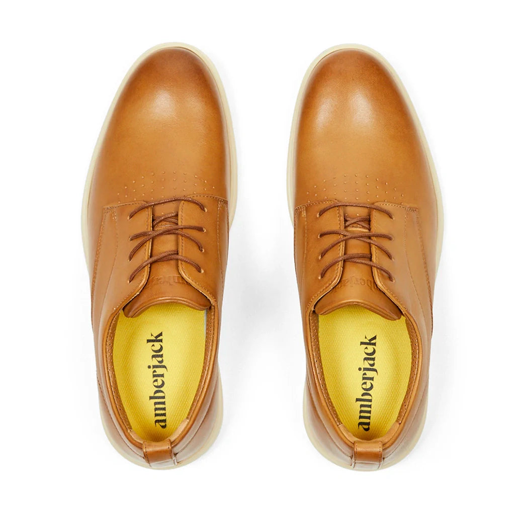 Pair of tan leather shoes with 'amberjack' branding on a white background