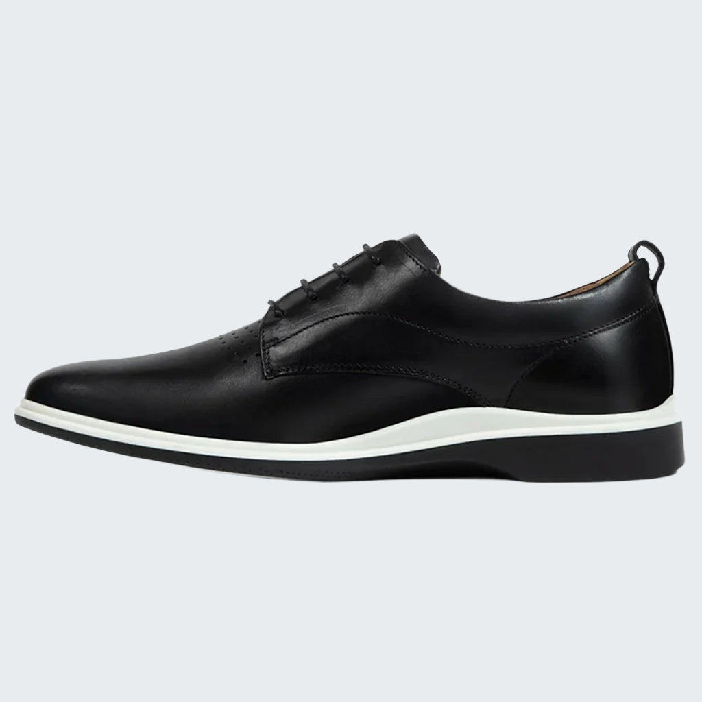 Black leather shoe with white sole on a white background