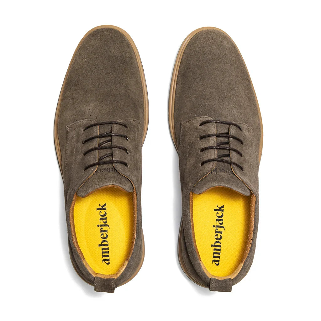 Brown suede shoes with yellow interior on a white background