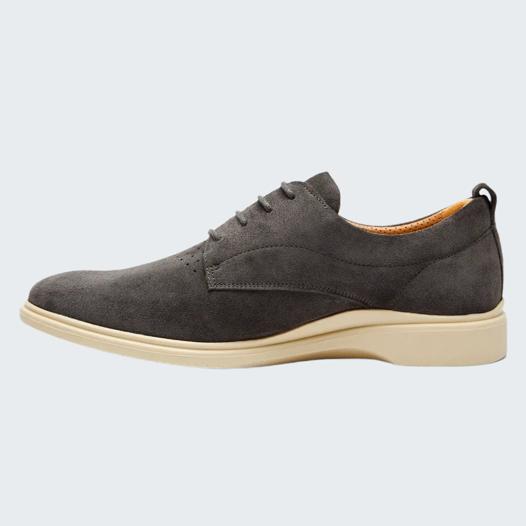 Gray suede shoe with a beige sole on a white background