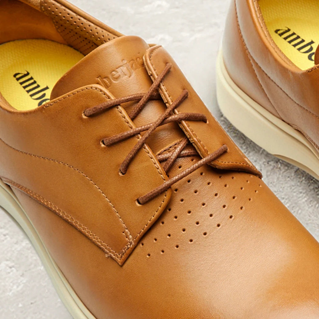 Brown leather shoes with visible brand name on a light background