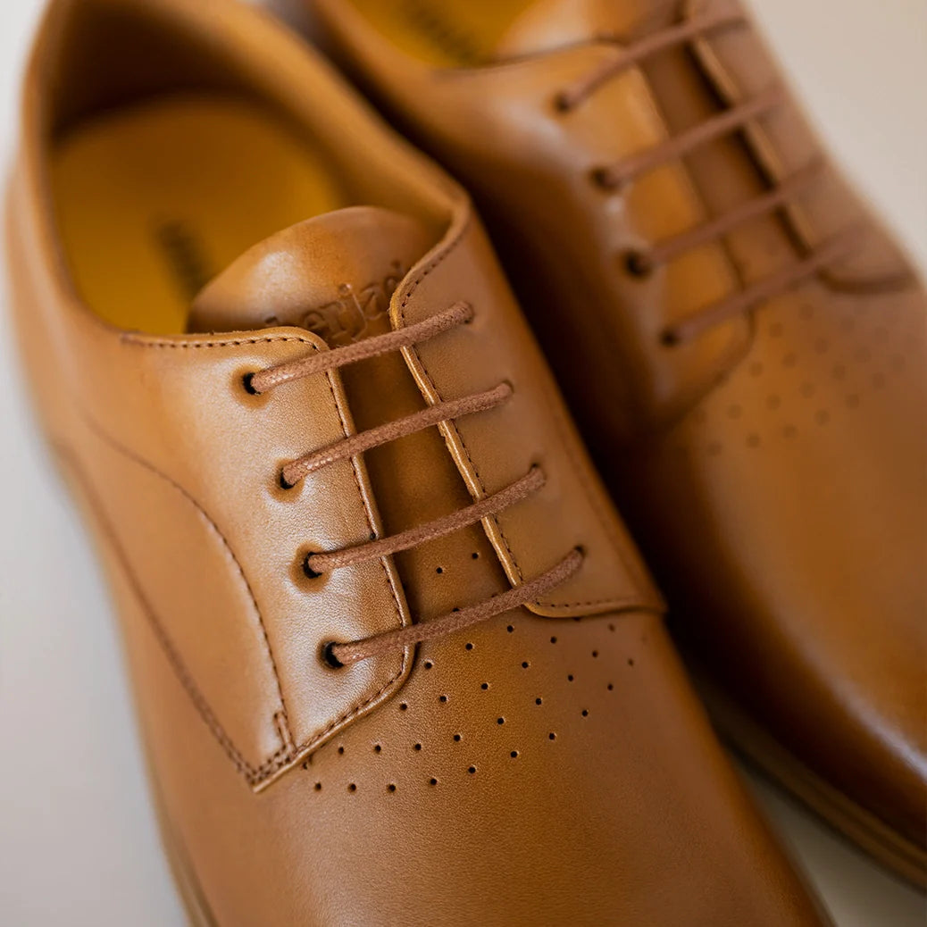 Close-up of brown leather shoes with laces on a light background