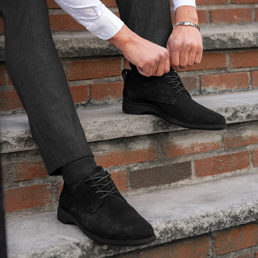 Person wearing black dress shoes on a brick staircase