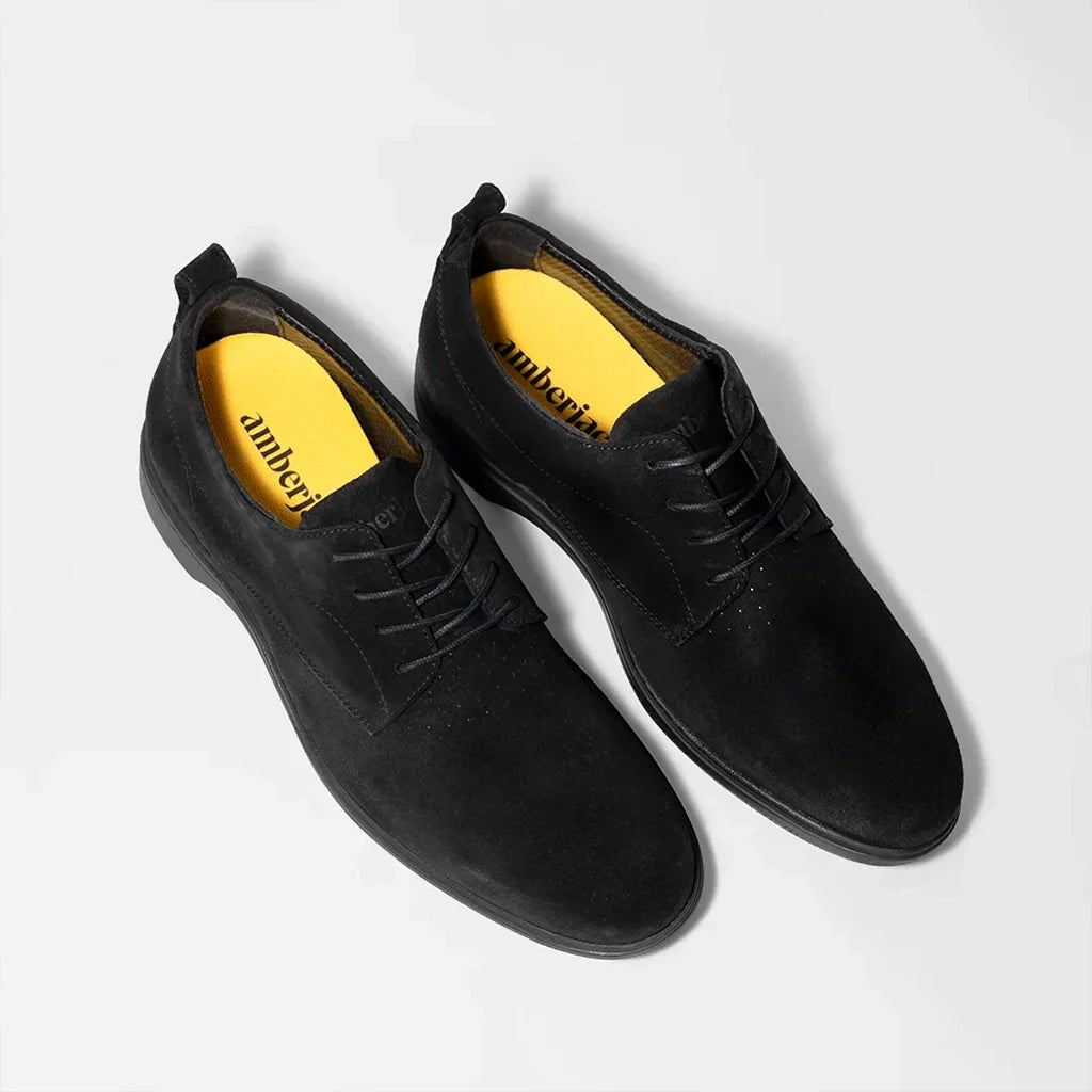 Black shoes with yellow lining on a white background