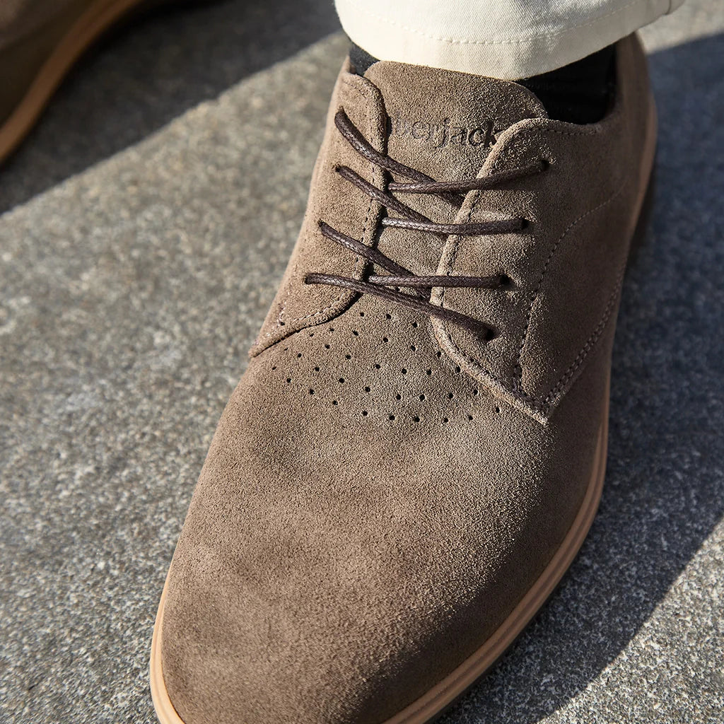 Brown suede shoe with 'Vagabond' branding on a concrete surface