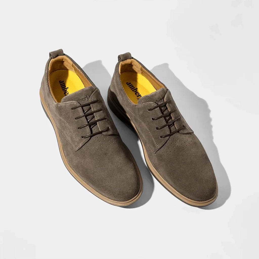 Pair of brown suede shoes on a light gray background