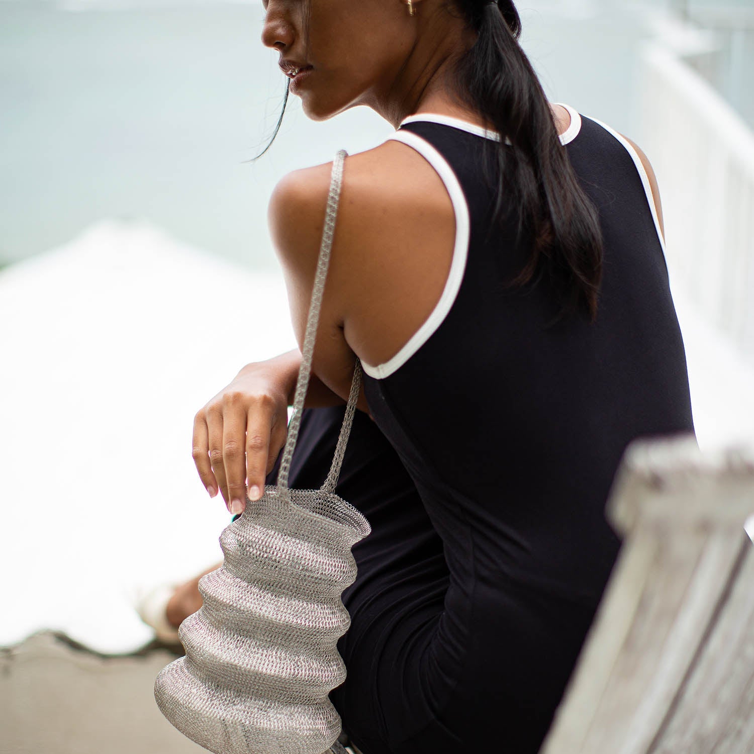 Woman holding a textured handbag with a blurred background