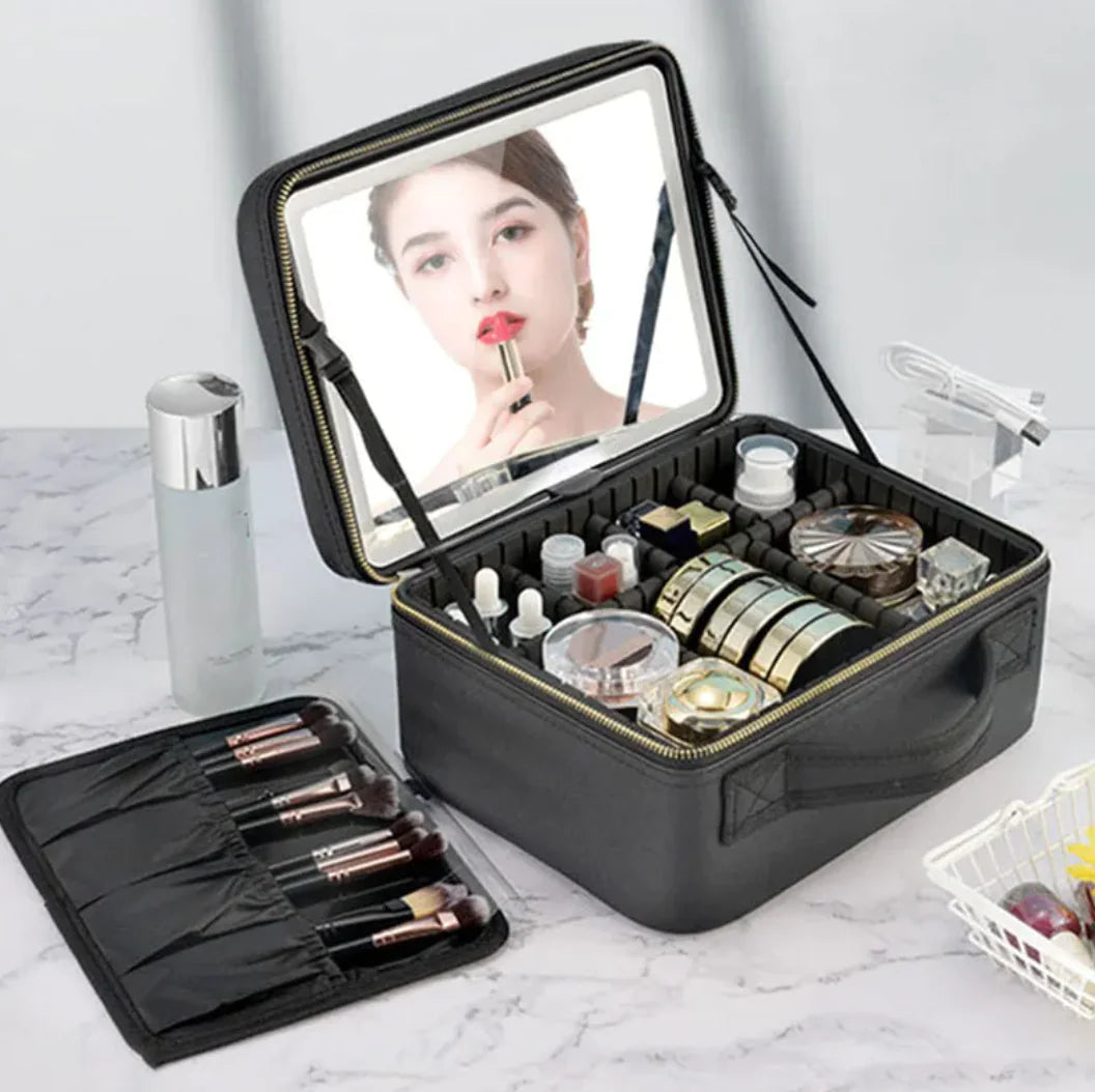 Black makeup case with mirror, brushes, and cosmetic items on a marble surface