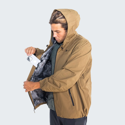 Man wearing a brown jacket with a hood, holding a white card or paper.