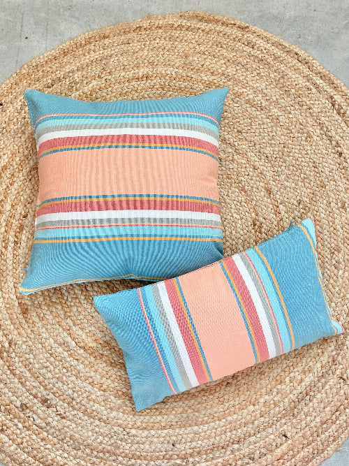 Two striped pillows on a woven mat