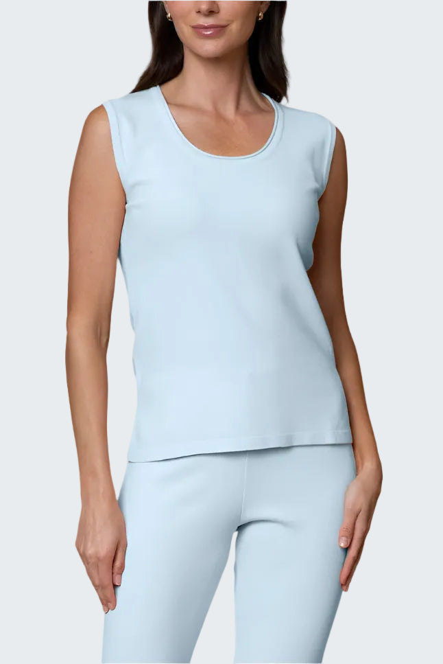 Woman wearing a light blue sleeveless top and leggings on a white background