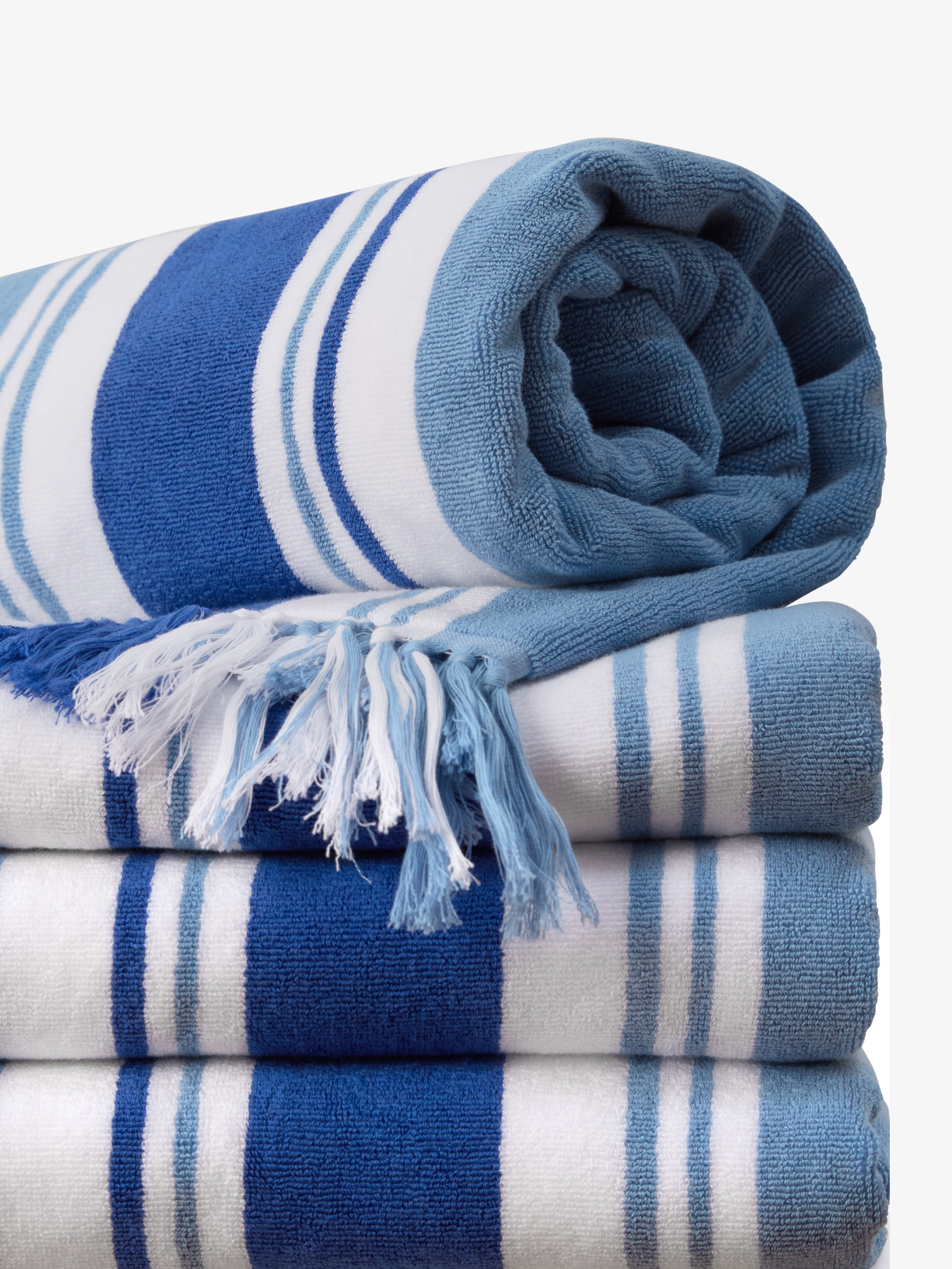 Stack of blue and white striped towels with a fringed edge on a white background