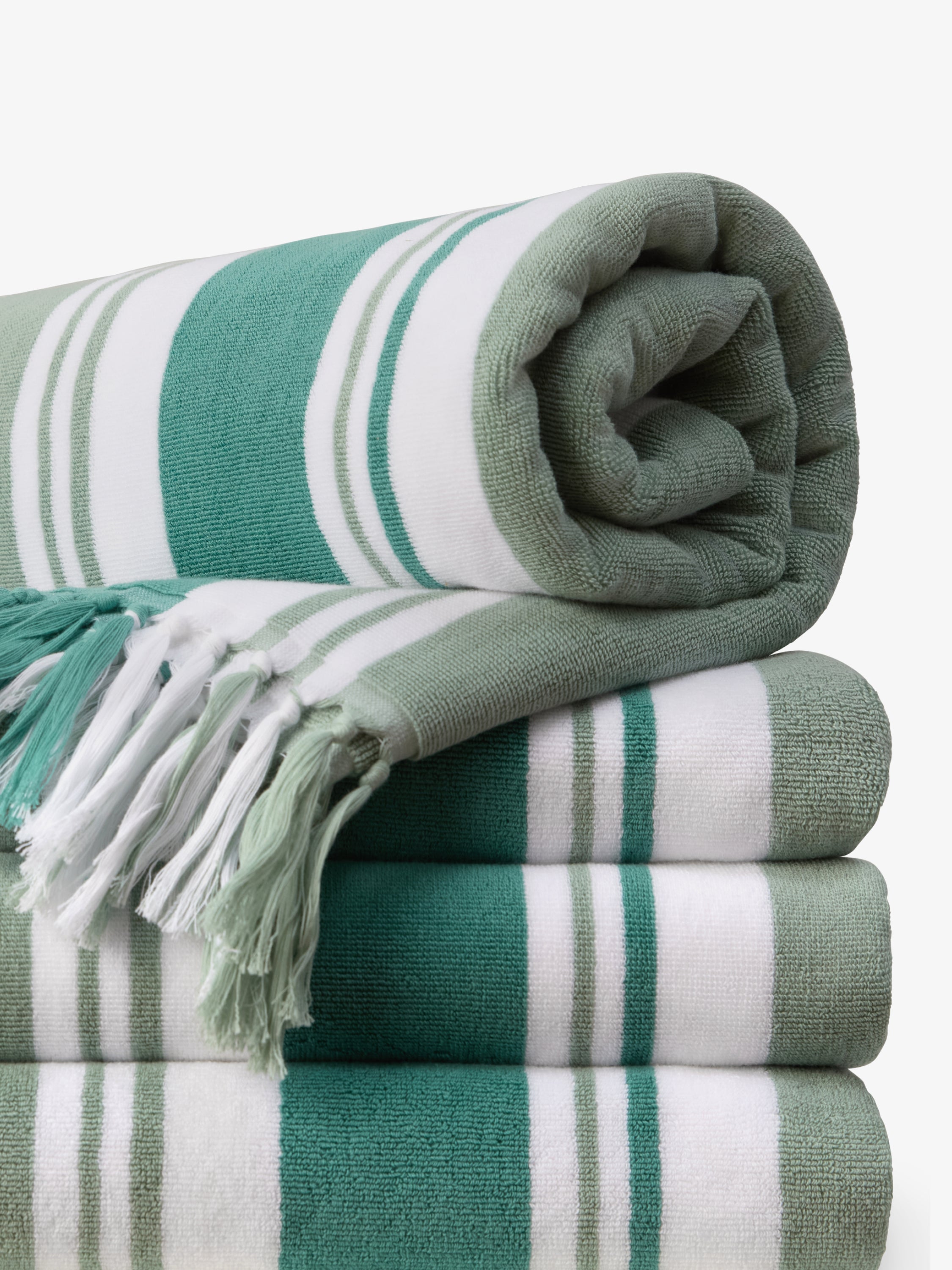 Stack of green and white striped towels on a white background