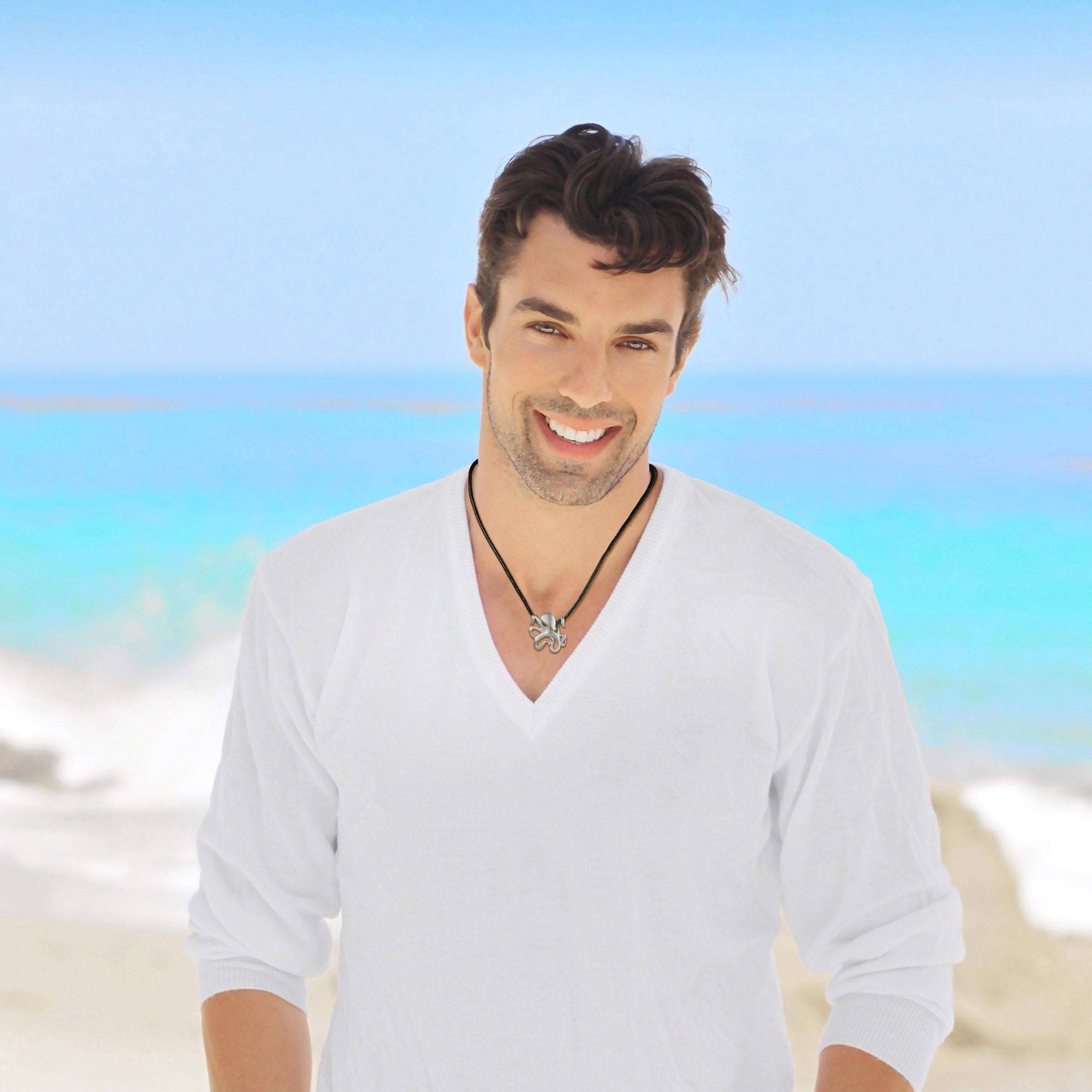 Man wearing a white shirt with a blurred beach background