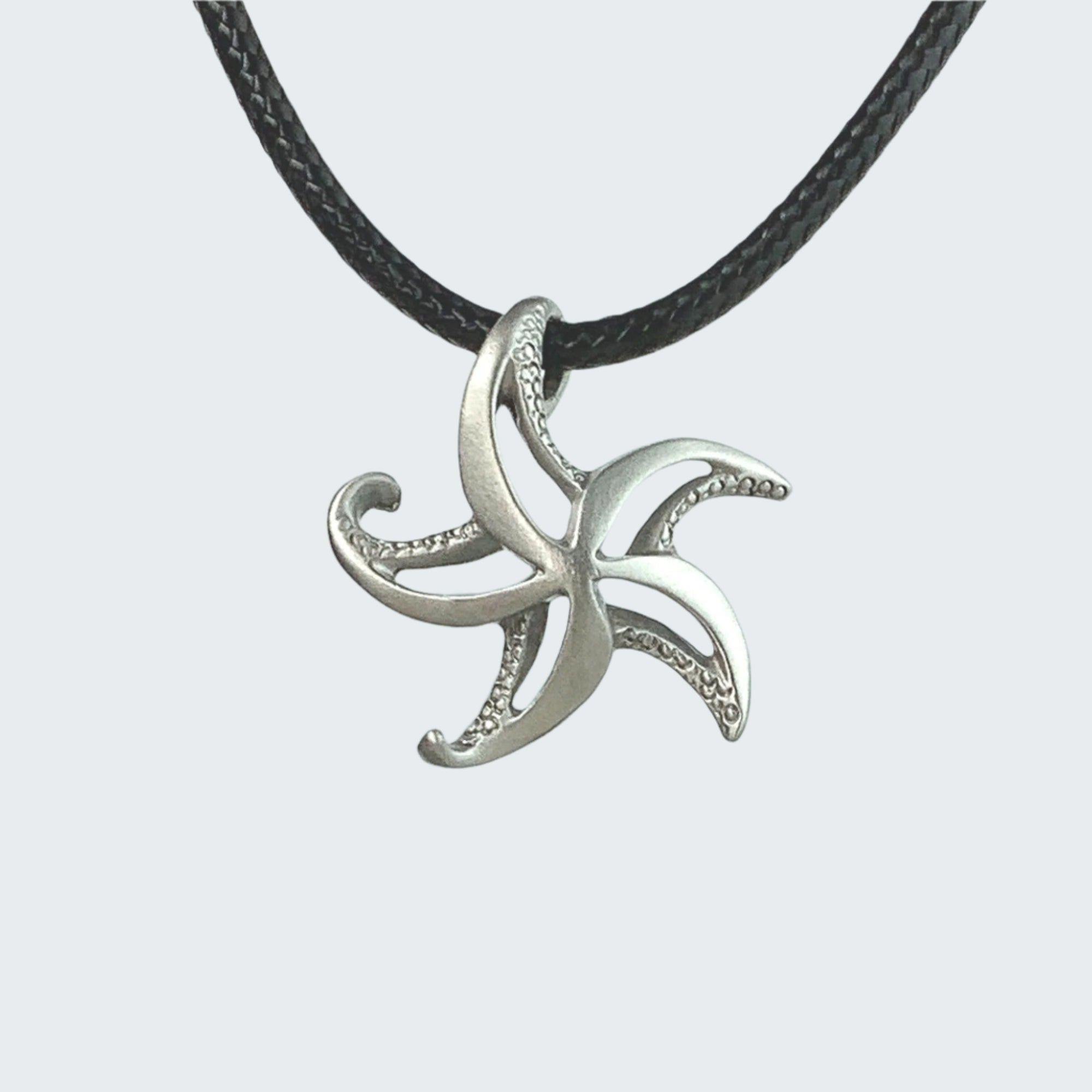Silver octopus pendant on a black cord against a light blue striped background