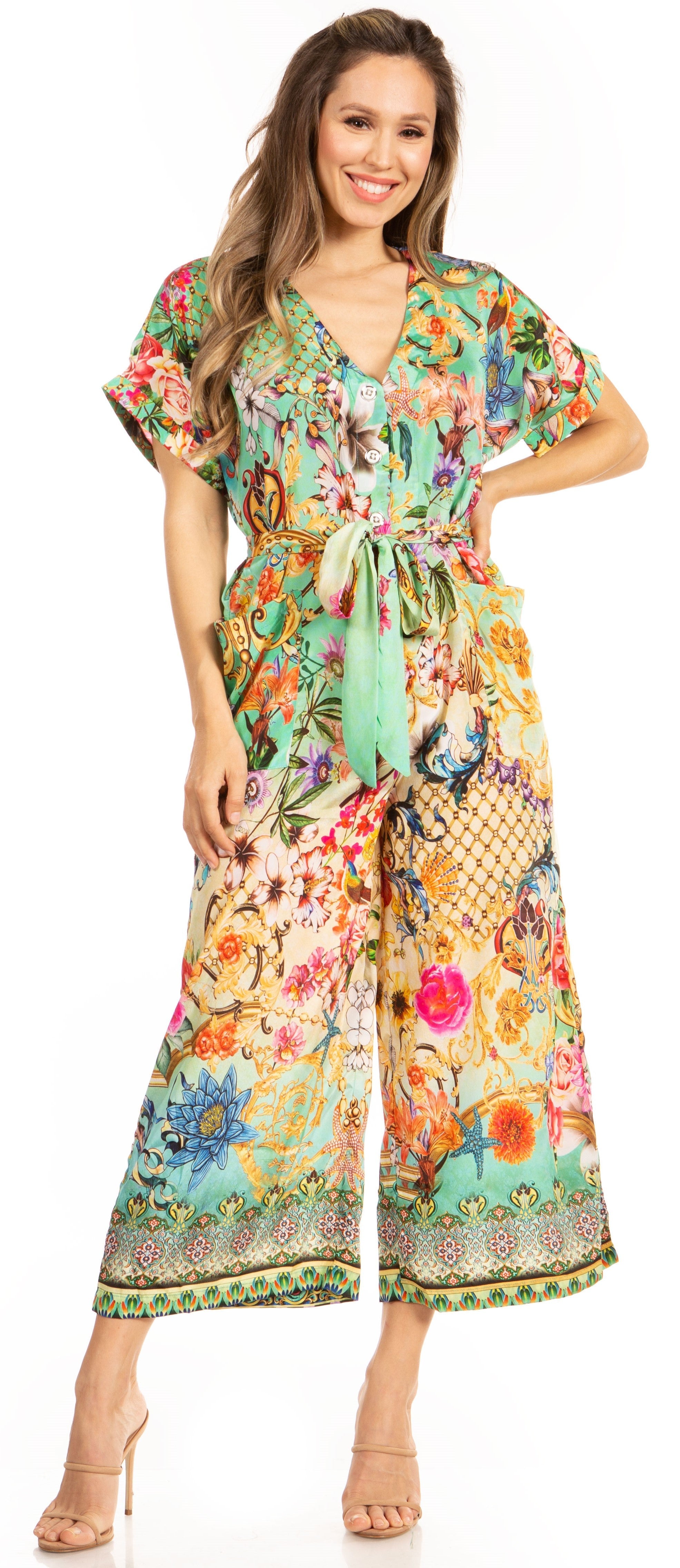 Woman wearing a colorful floral dress with a belt, standing against a plain background.