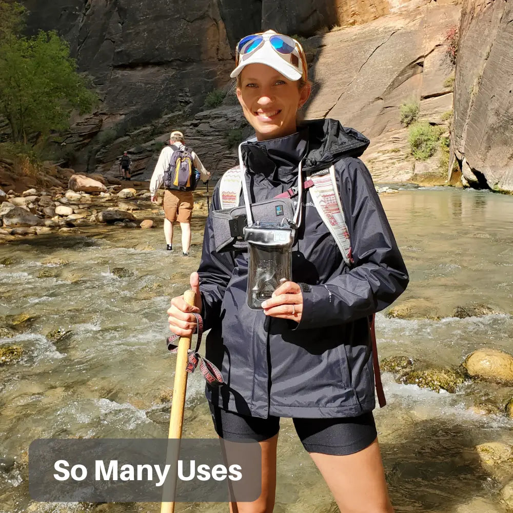 Person hiking by a river with outdoor gear, holding a water filter.