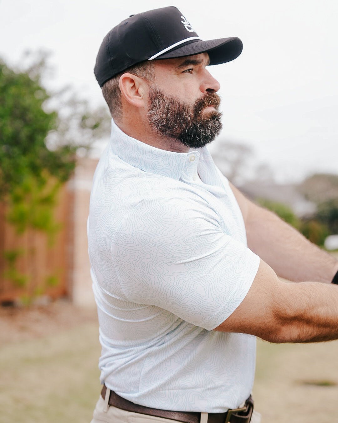 Man wearing a black cap and white shirt outdoors