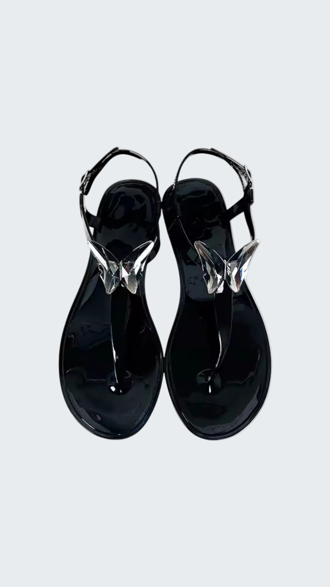 Black sandals with clear straps on a white background