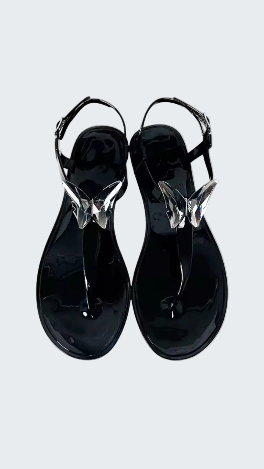 Black jelly sandals with clear straps on a white background