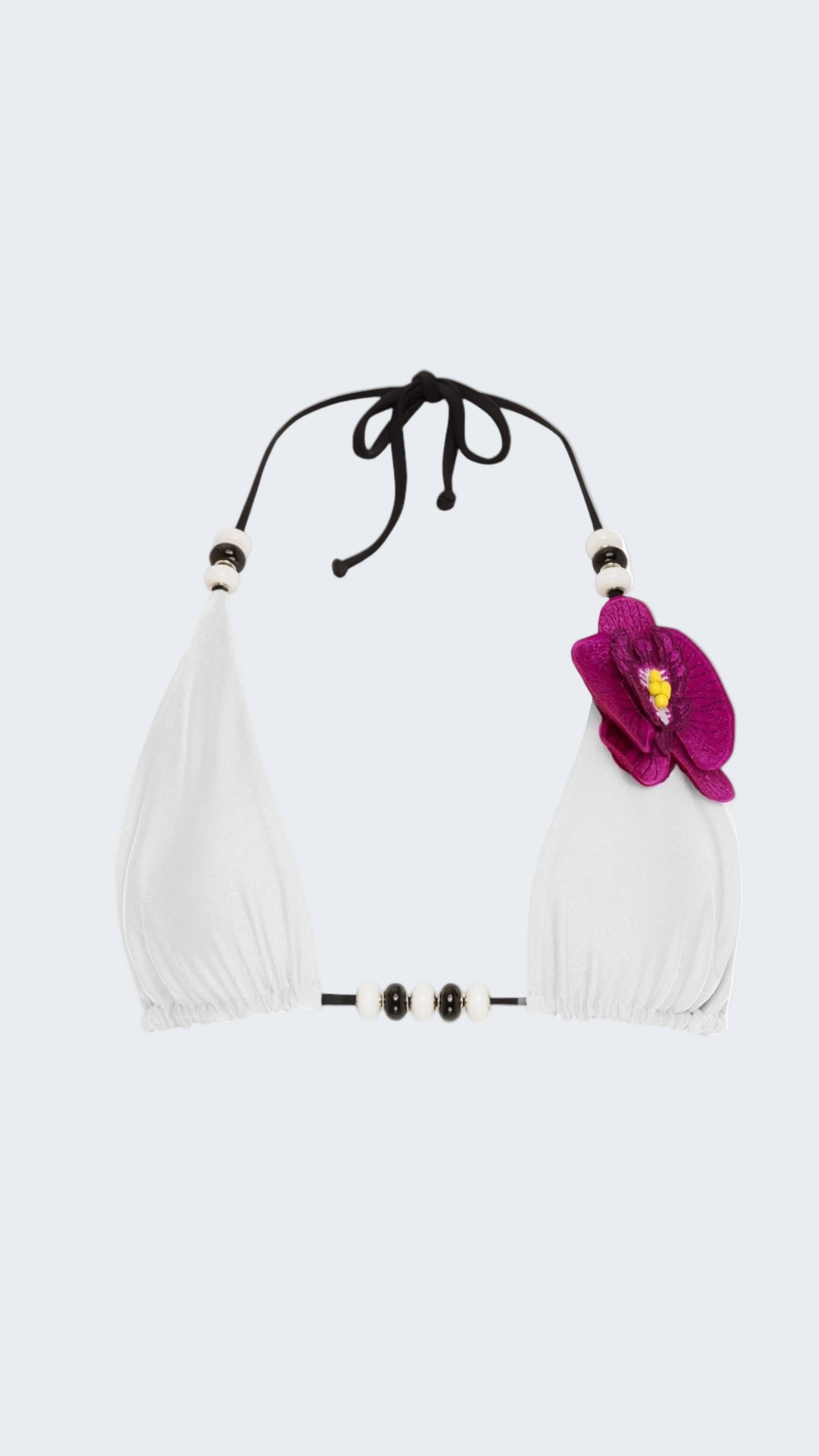 White bikini top with black straps and a pink flower on a white background