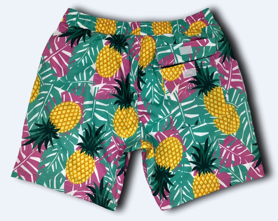 Colorful shorts with pineapple and leaf pattern on a light gray background