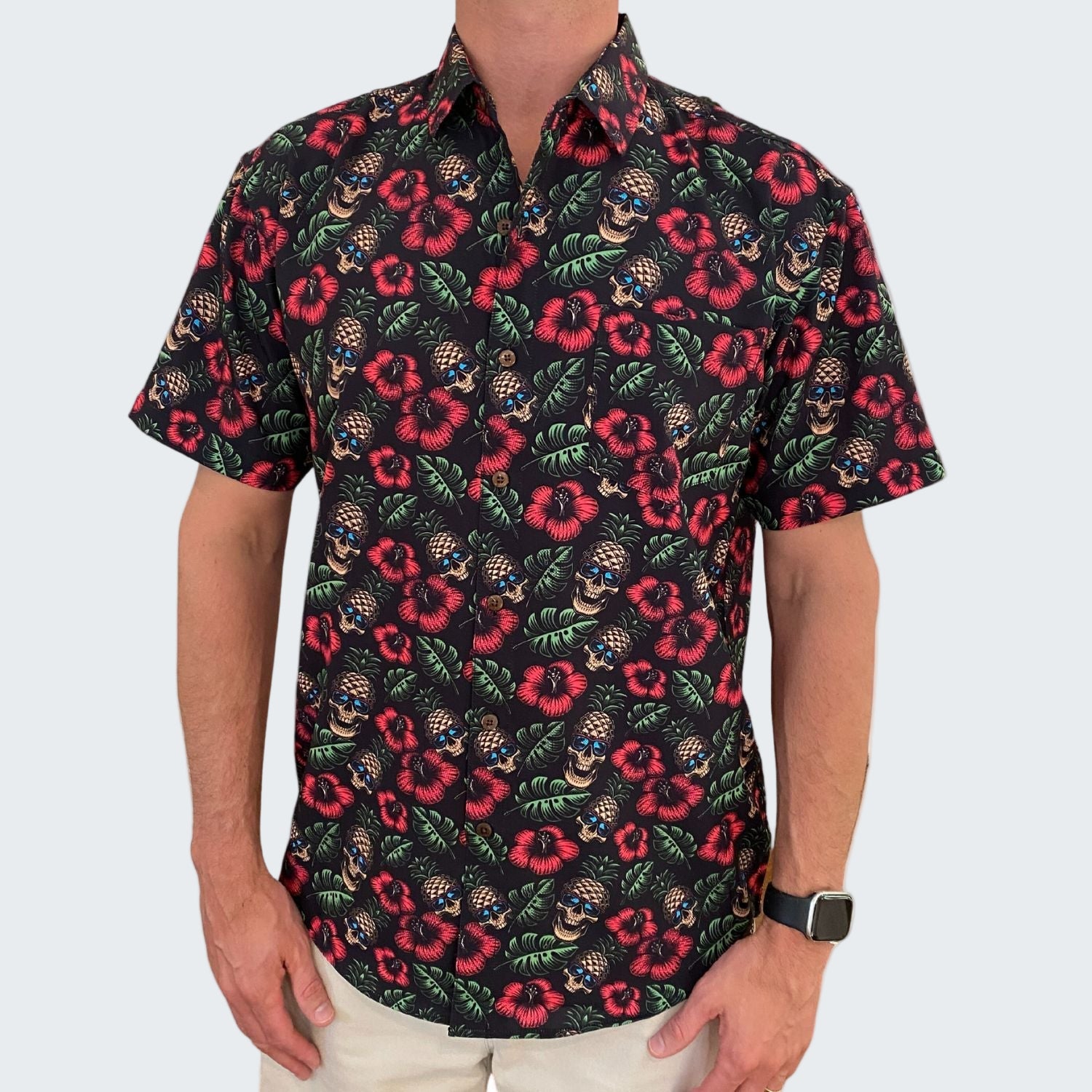 Man wearing a black floral patterned shirt on a white background