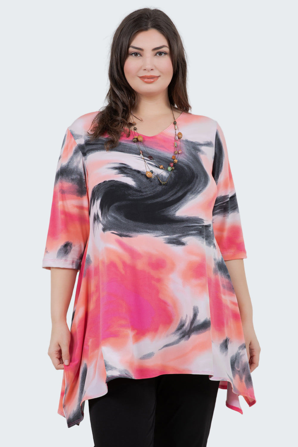 Woman wearing a colorful tie-dye shirt against a white background