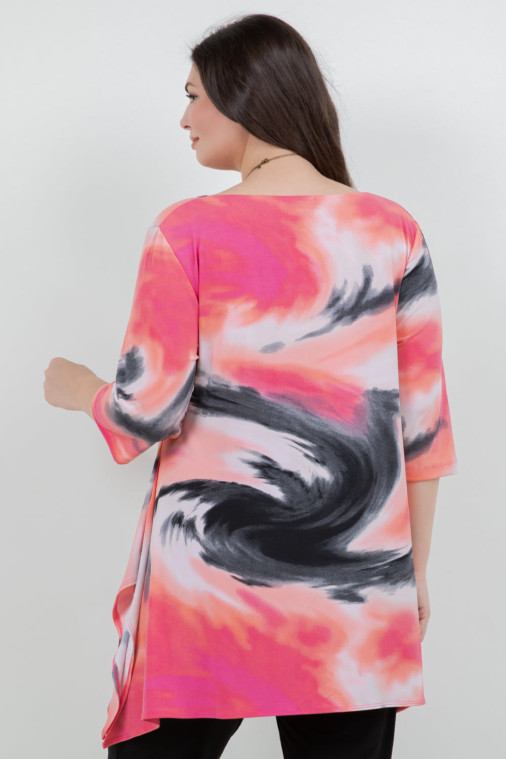 Woman wearing a colorful abstract patterned top on a plain background