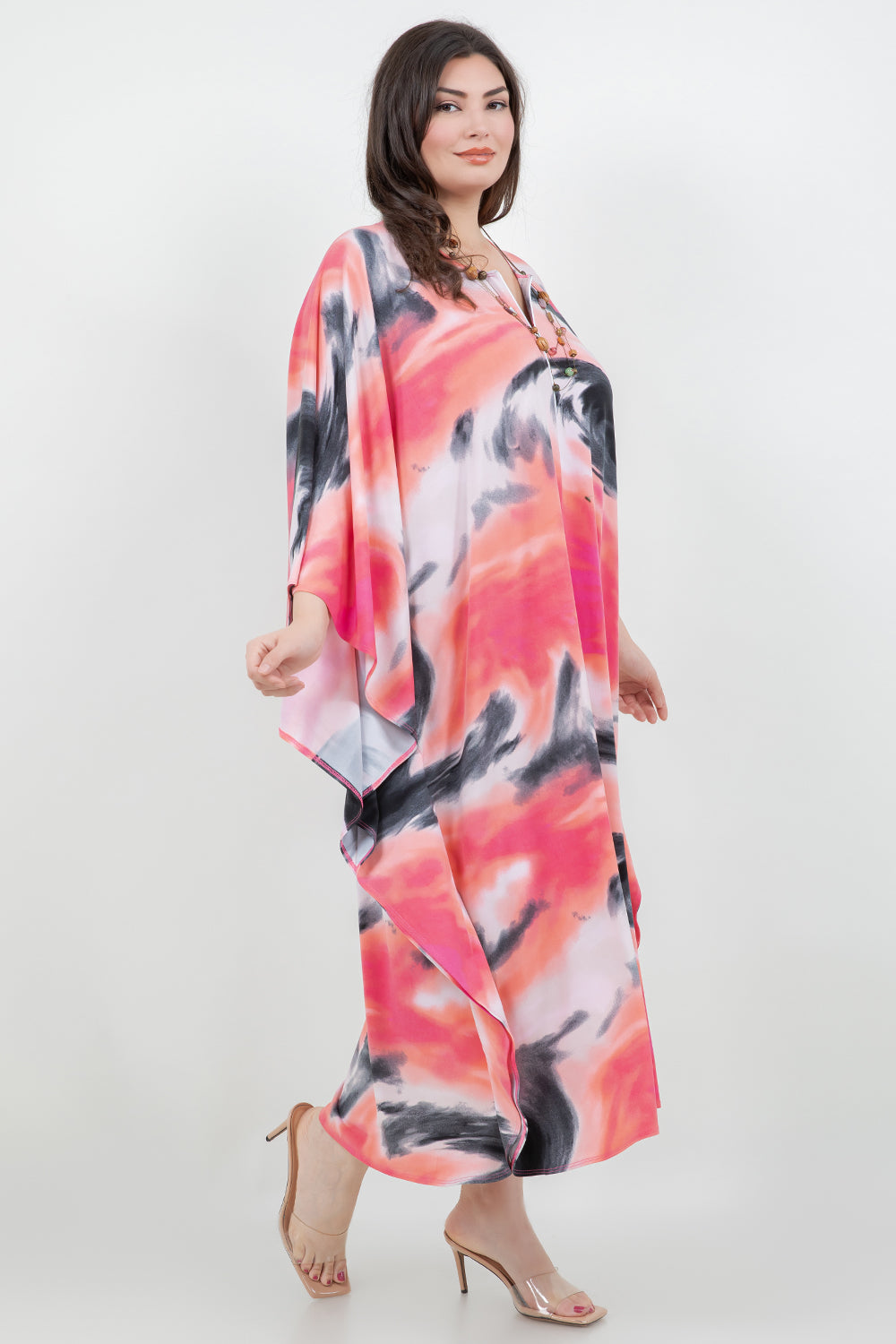 Woman wearing a colorful dress with abstract patterns on a white background