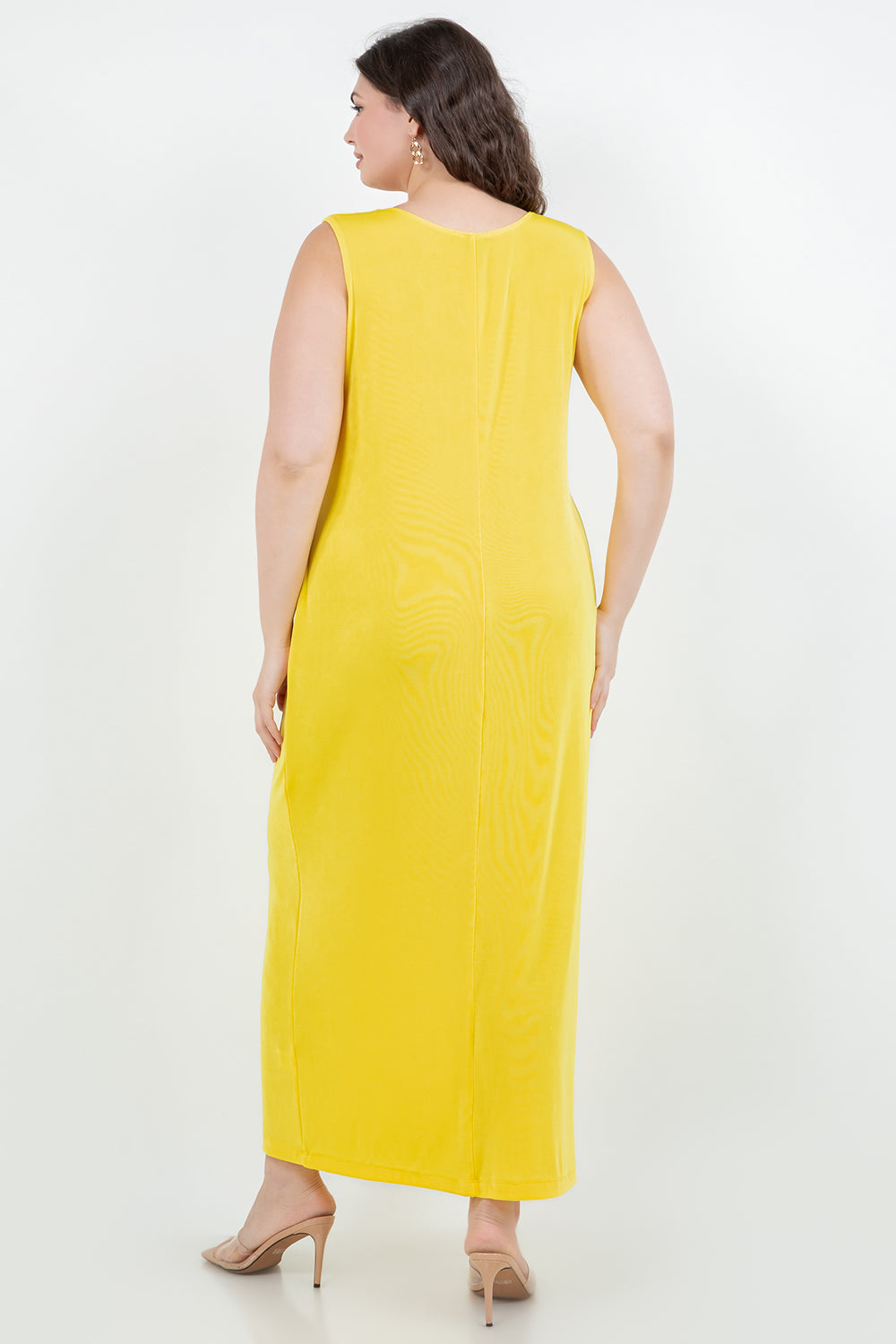 Woman wearing a yellow sleeveless dress on a white background